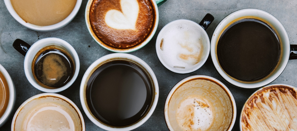 An assortment of various, filled, coffee cups.
